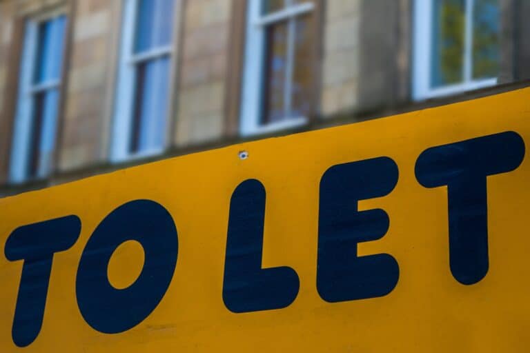 A 'To Let' sign with a residential building in the background in the concept of affordable housing in Ealing.